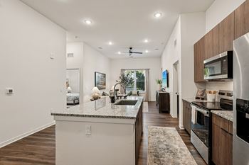 A modern kitchen with a marble countertop and stainless steel appliances